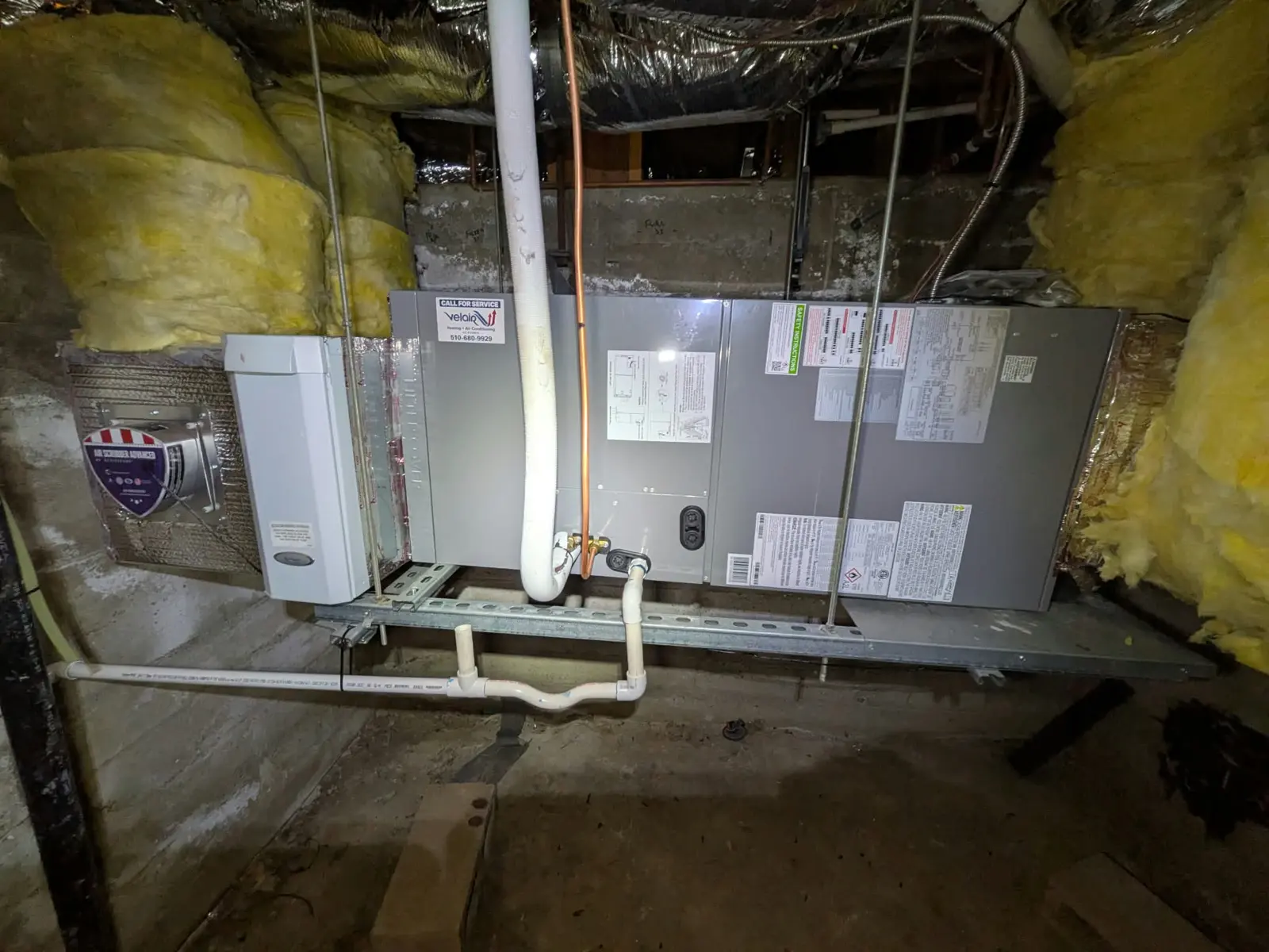A new air handler installed under a house, with the Velair service sticker.