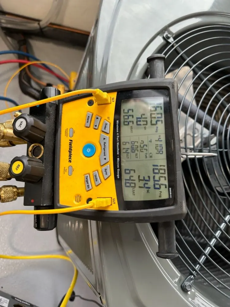 Refrigerant gauges connected during an AC service.